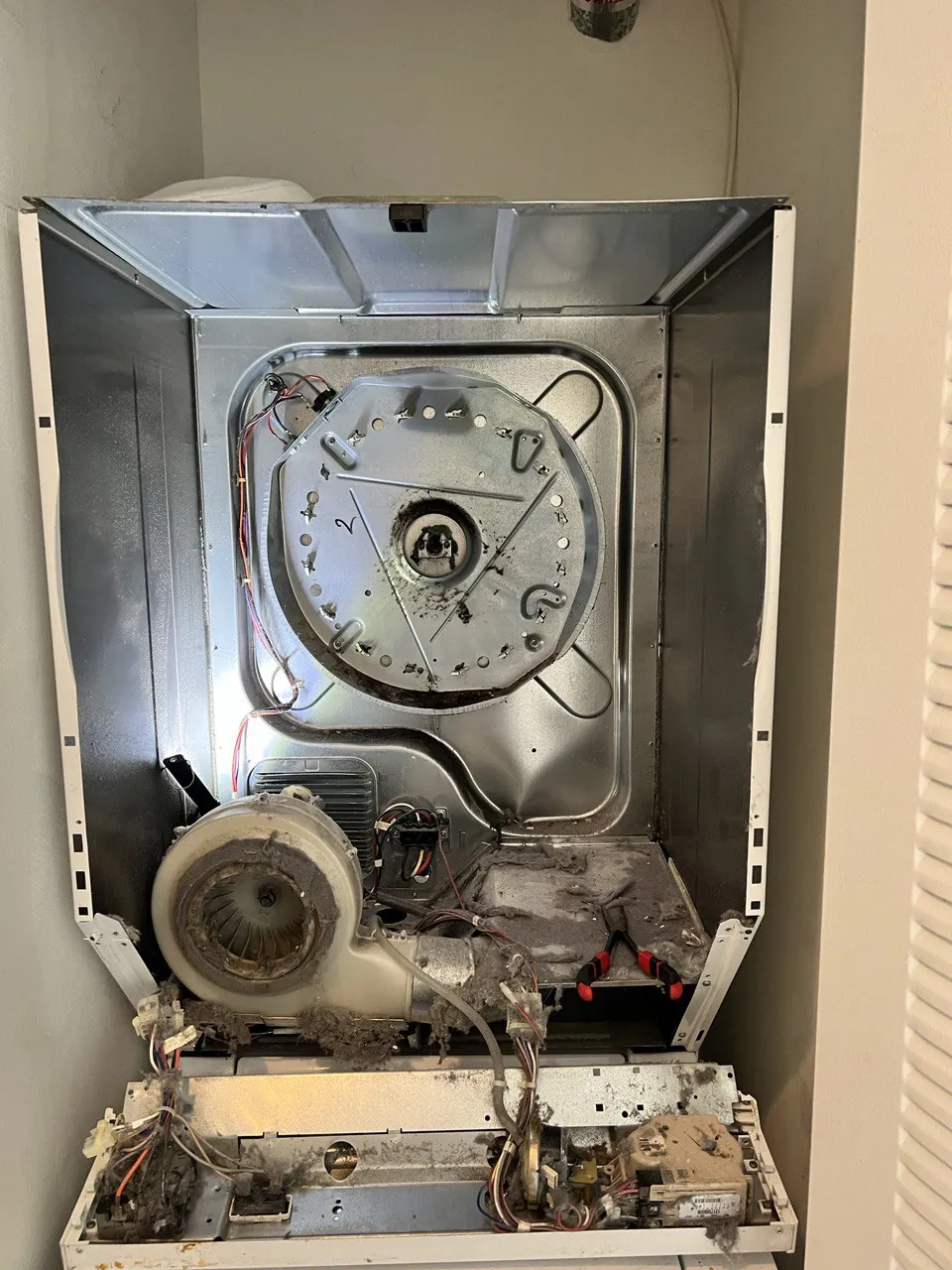 Dryer opened up with the drum removed, blower housing and heating
                         element exposed