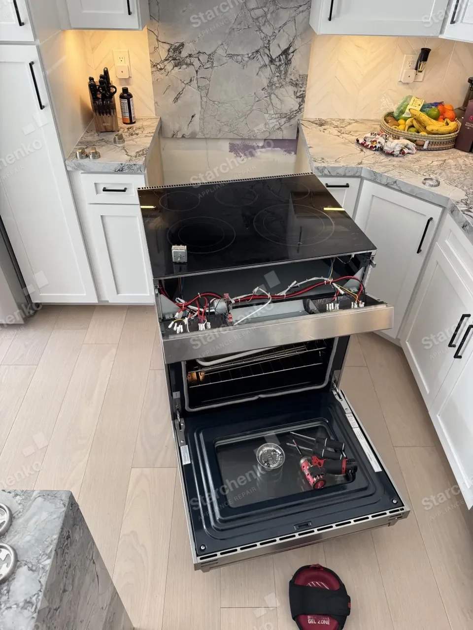 Slide-in Thermador range with the cooktop lifted and the oven door open