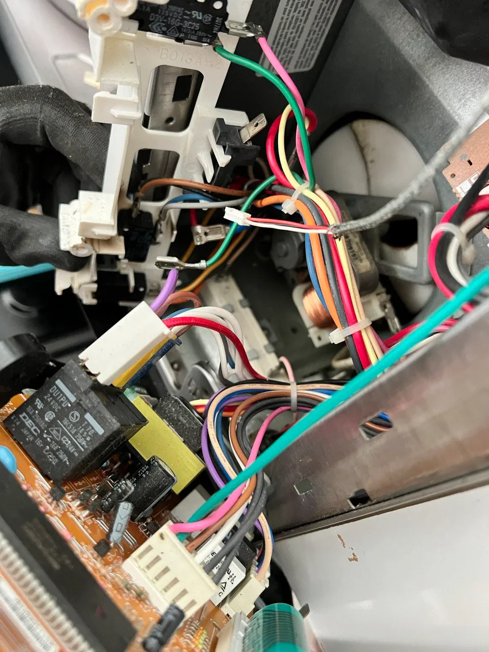 Microwave opened up with the door interlock switches, wiring harness and control board exposed