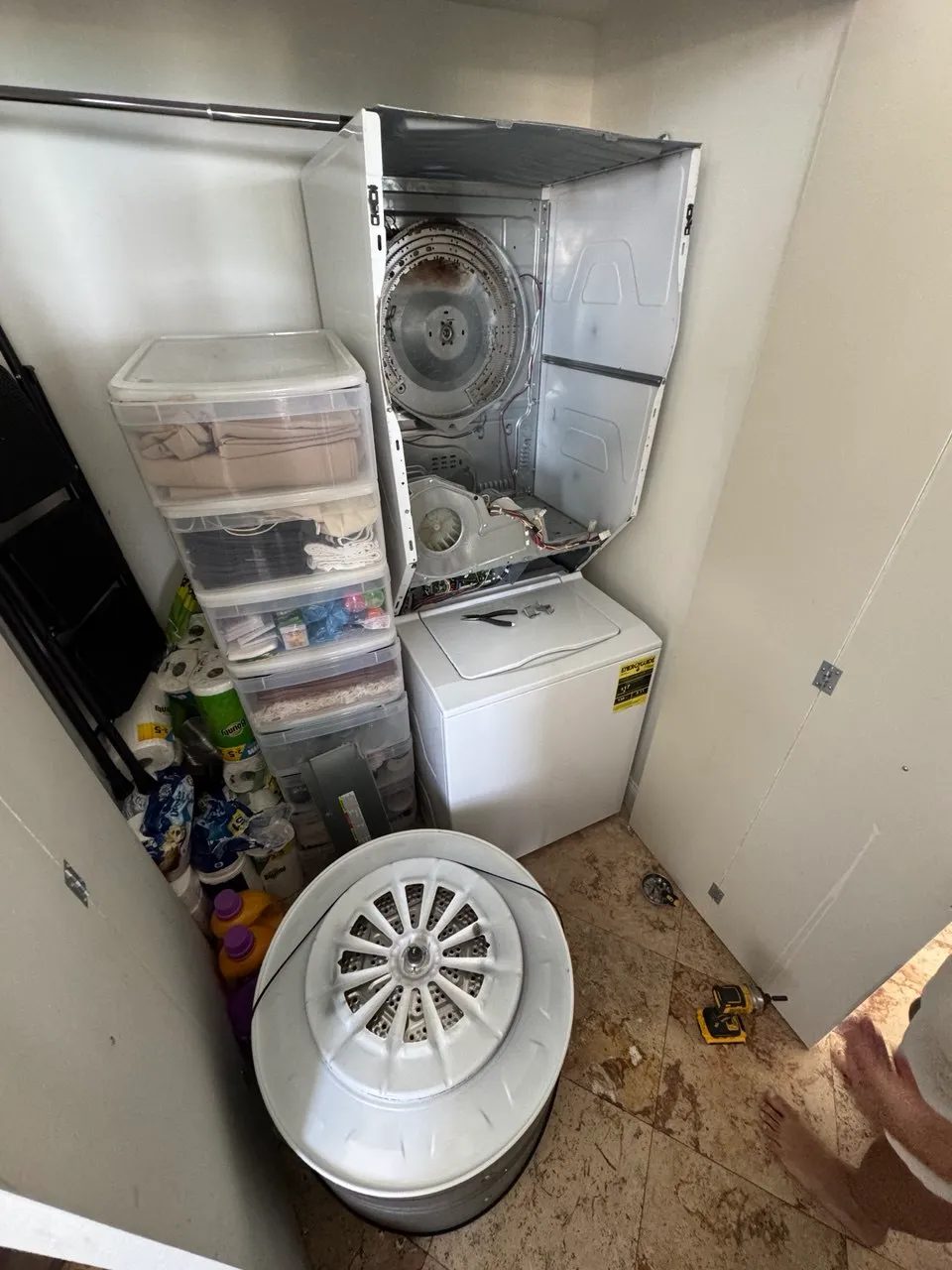 Stacked laundry center opened up with the dryer drum removed and standing on the floor