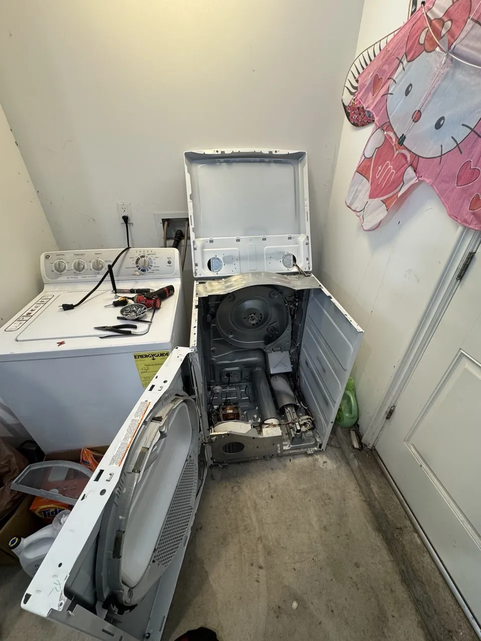 Gas dryer with the front panel removed in a laundry closet