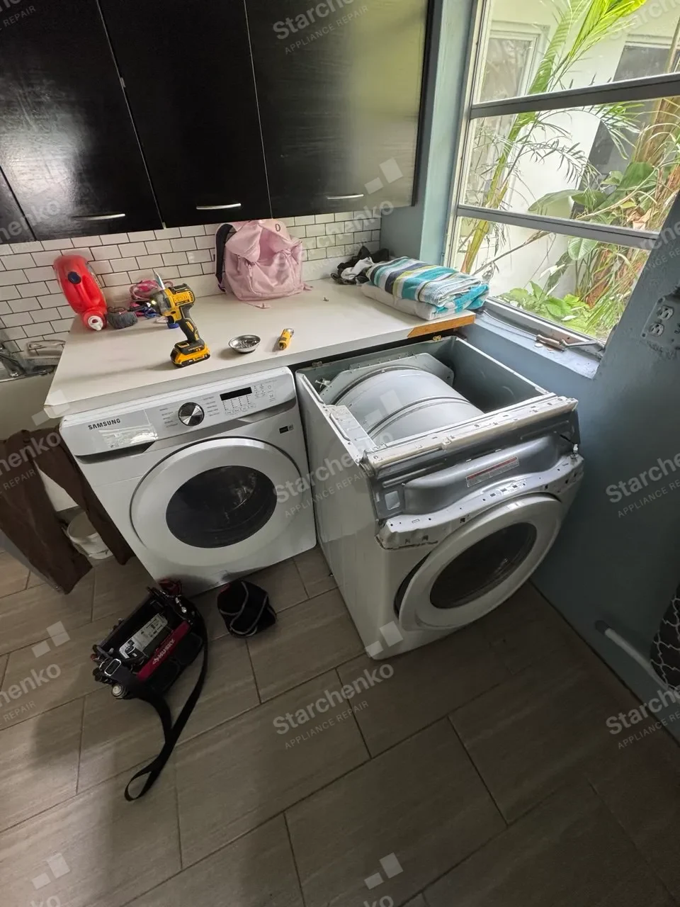 Samsung dryer with the front panel and bulkhead off beside its matching washer