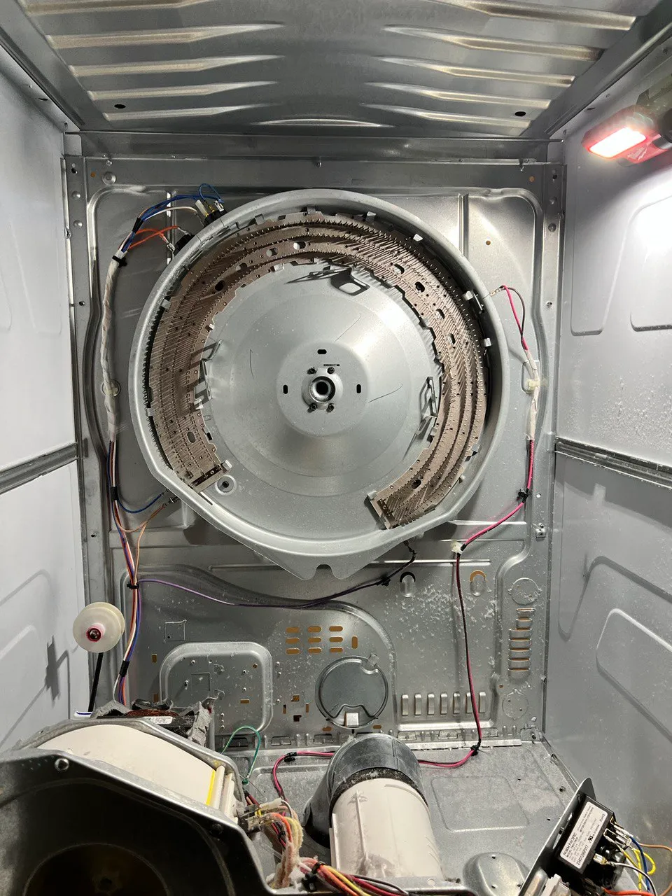 Electric dryer opened with the drum out and the drive motor and its switch exposed