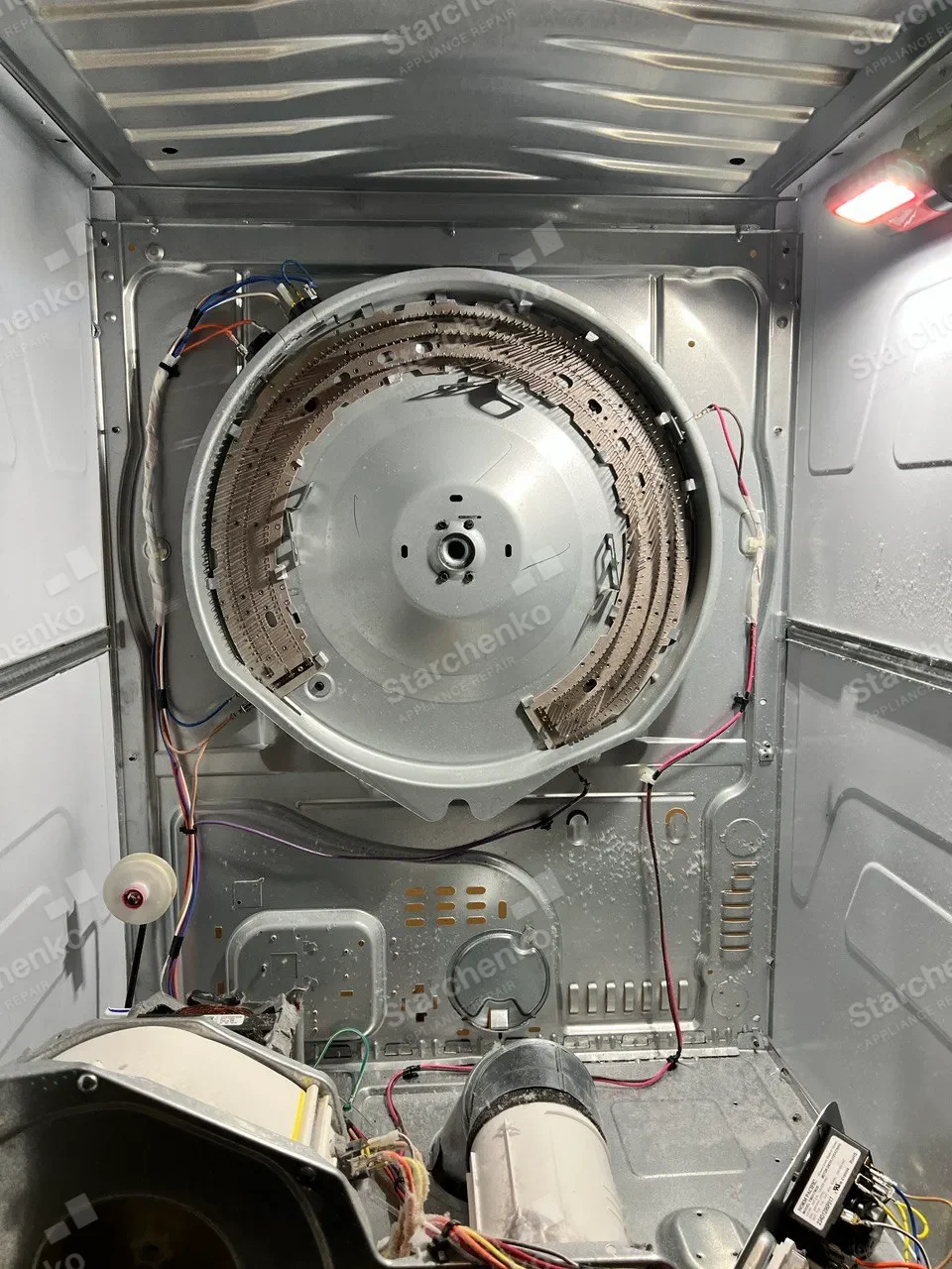 Electrolux dryer opened from the rear with the heating assembly, wiring and drive components exposed