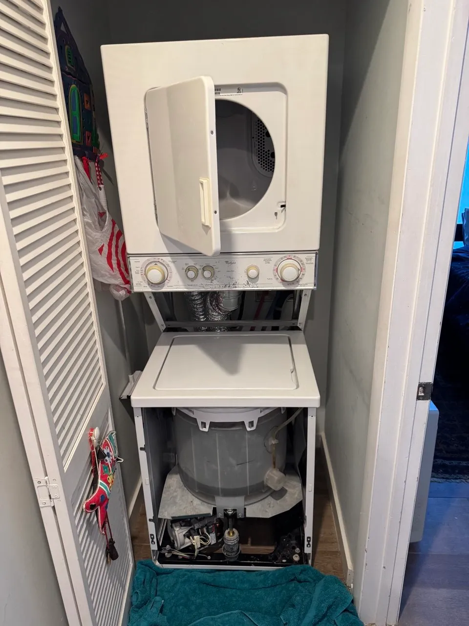 Stacked laundry center opened with the washer tub and lower components exposed