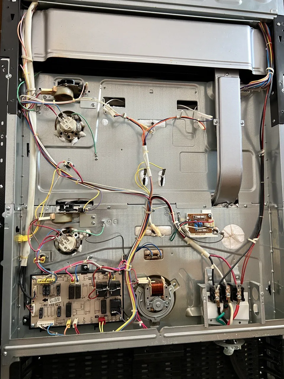 Range with the rear service panel off: wiring harness, control board
                         and the cooling fan exposed