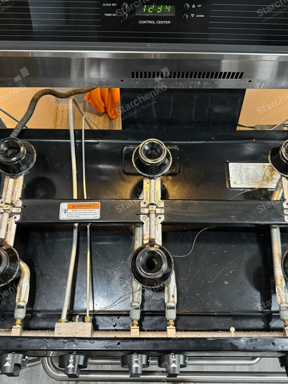 Thermador cooktop lifted above the counter with the burner assemblies exposed