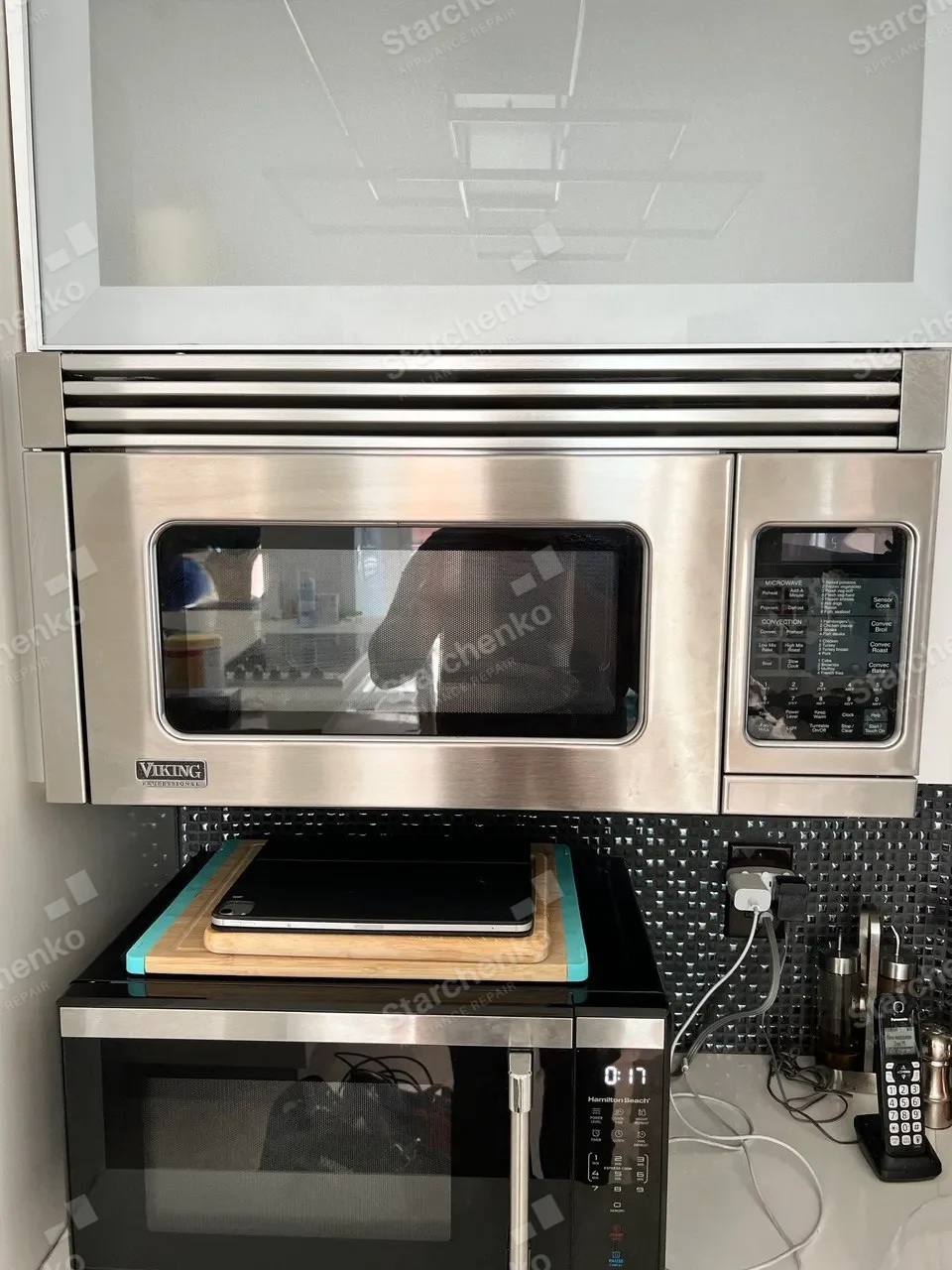 Viking Professional built-in microwave mounted under a white cabinet above a black tile backsplash
