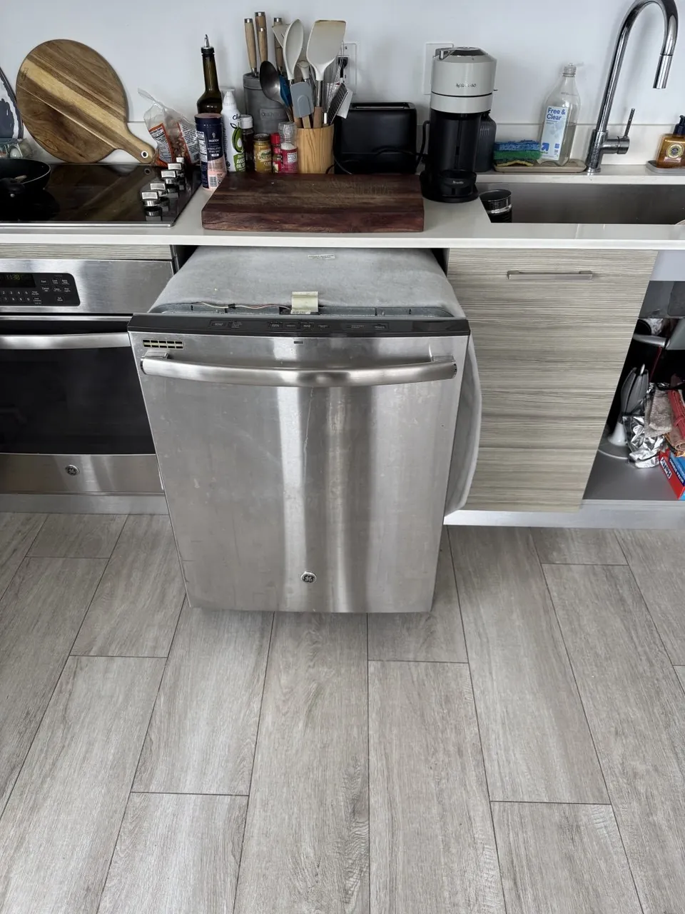 Stainless dishwasher pulled out from under the counter onto the
                         kitchen floor