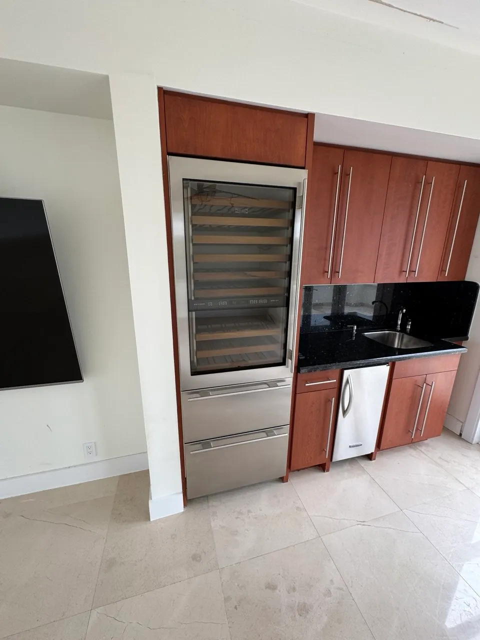 Built-in wine cooler in a bar counter beside a dishwasher