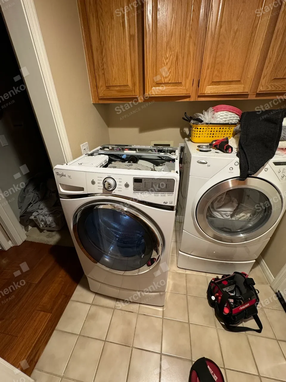Whirlpool front-load washer and dryer pair with the top panels removed