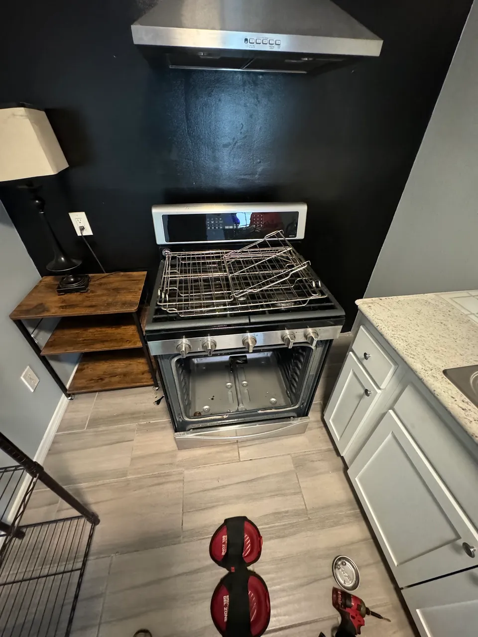 Gas range with the oven racks out and the oven floor panel removed during the repair