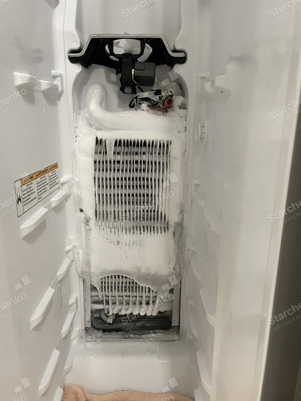 Liebherr freezer evaporator covered in frost from top to bottom with the rear panel removed