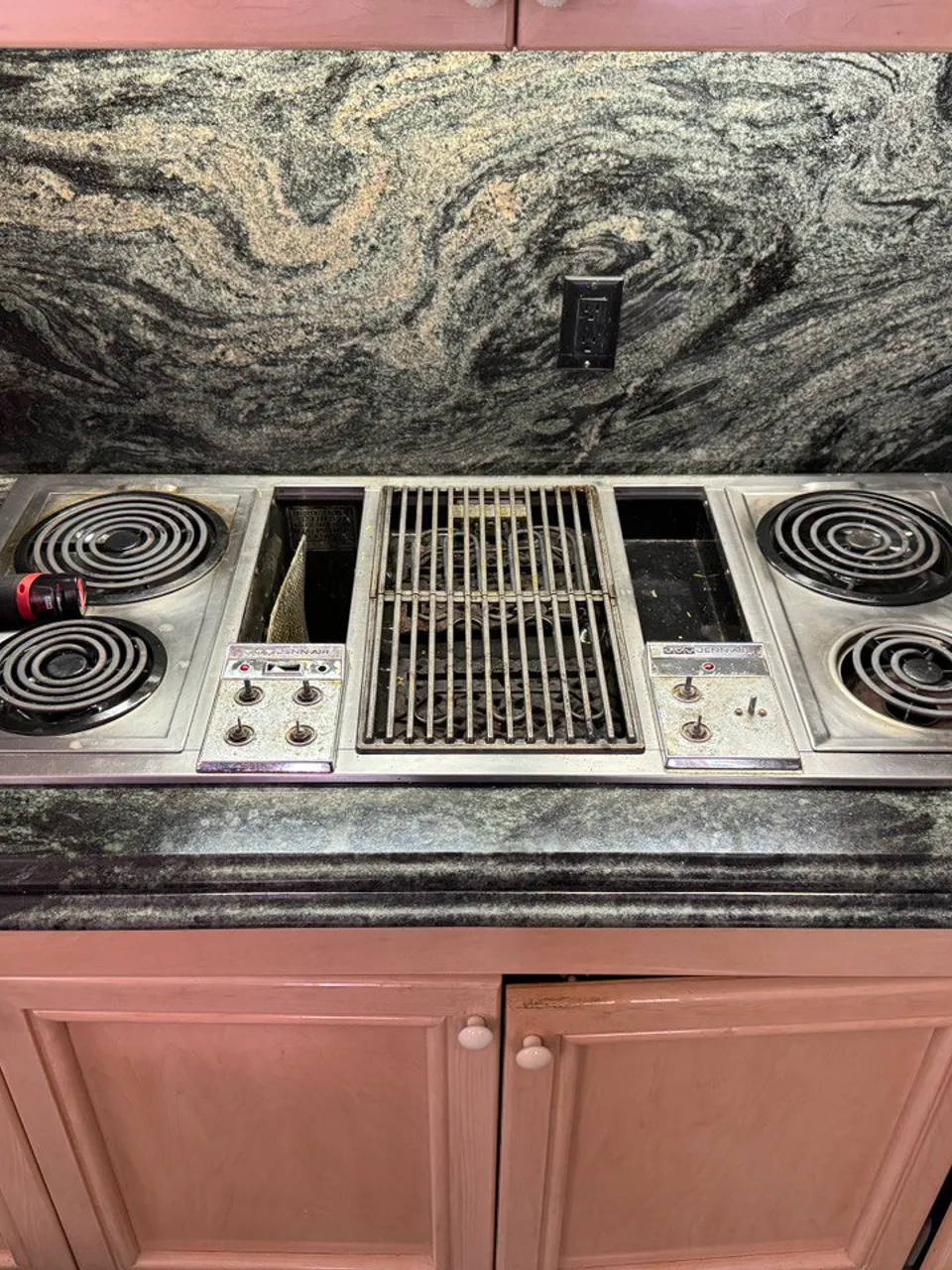 Electric coil cooktop with an integrated grill set into a granite countertop
