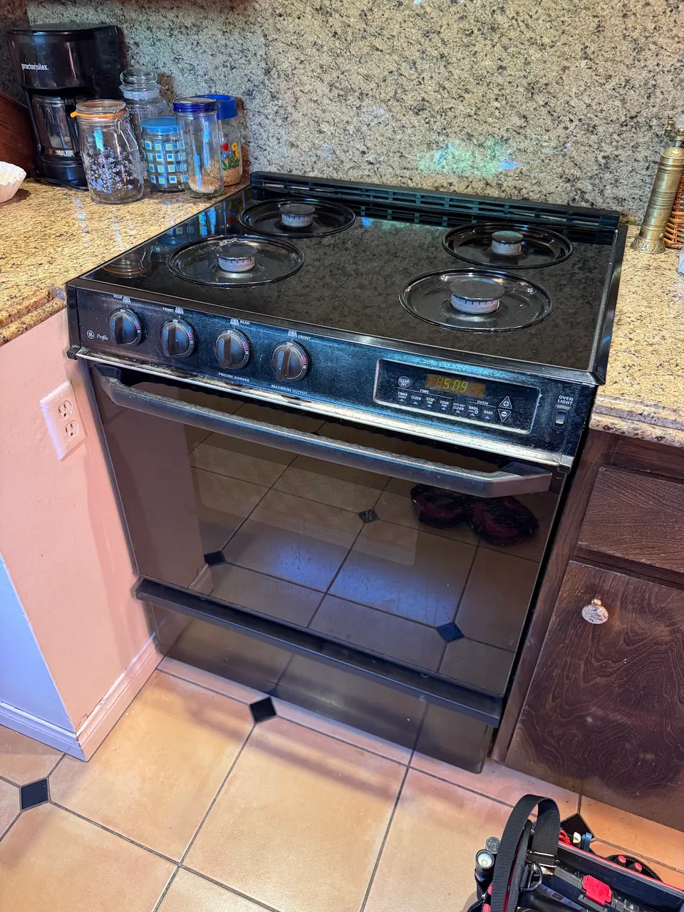Black gas range installed between kitchen cabinets