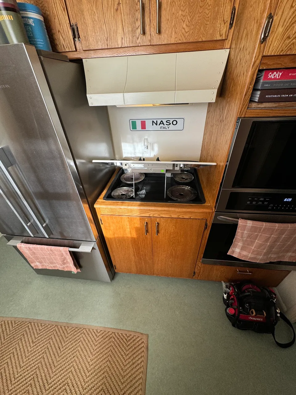 Gas cooktop with the burner top lifted to reach the igniters and burner assembly