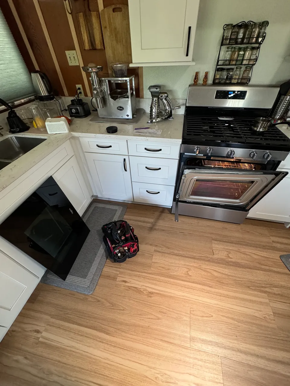 White kitchen with a stainless gas range and the oven door open