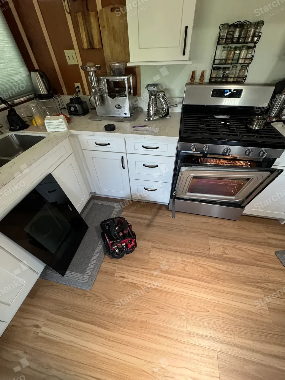 White kitchen with a stainless Samsung gas range and the oven door open