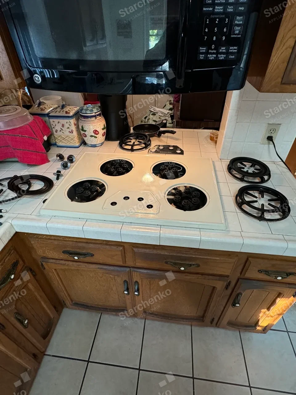 GE gas cooktop disassembled with the burner assemblies exposed