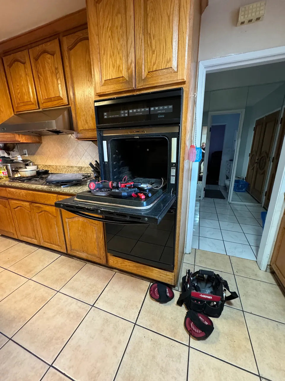 Black wall oven with a microwave above it in an oak kitchen