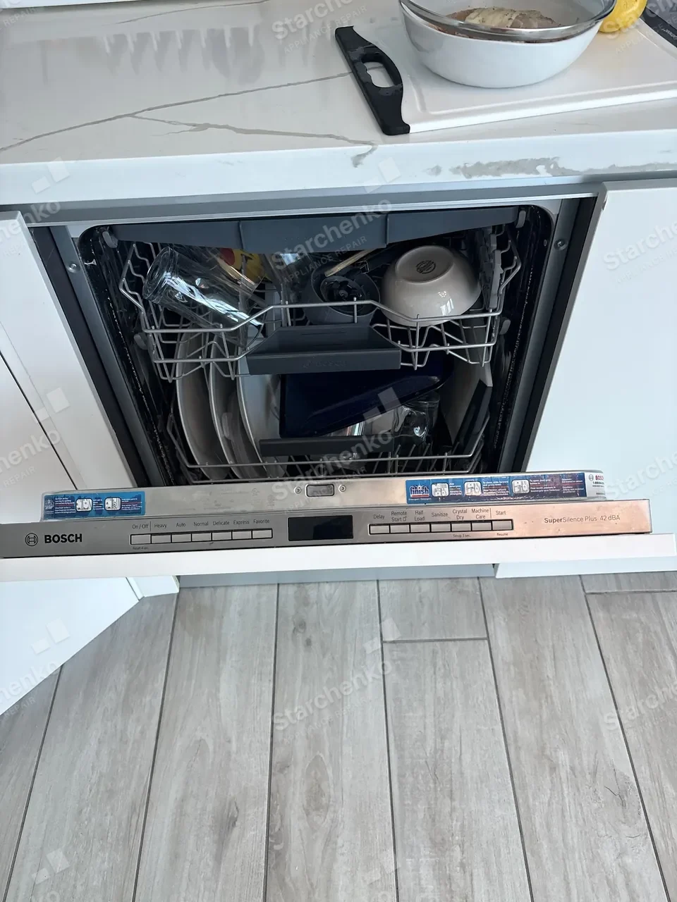 Bosch built-in dishwasher with the door open and a rack rail removed