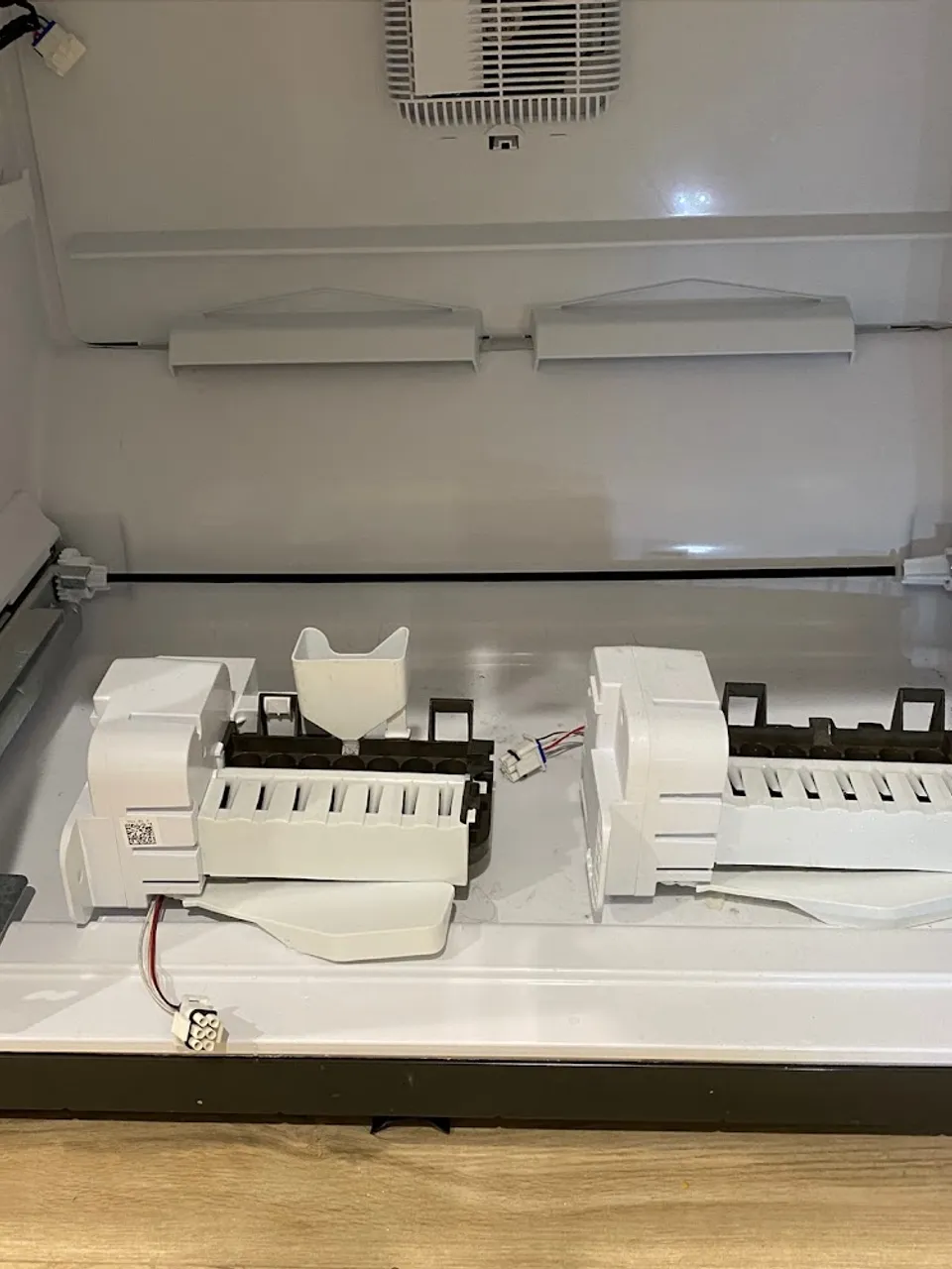 Ice maker assembly and wiring exposed inside the open freezer drawer