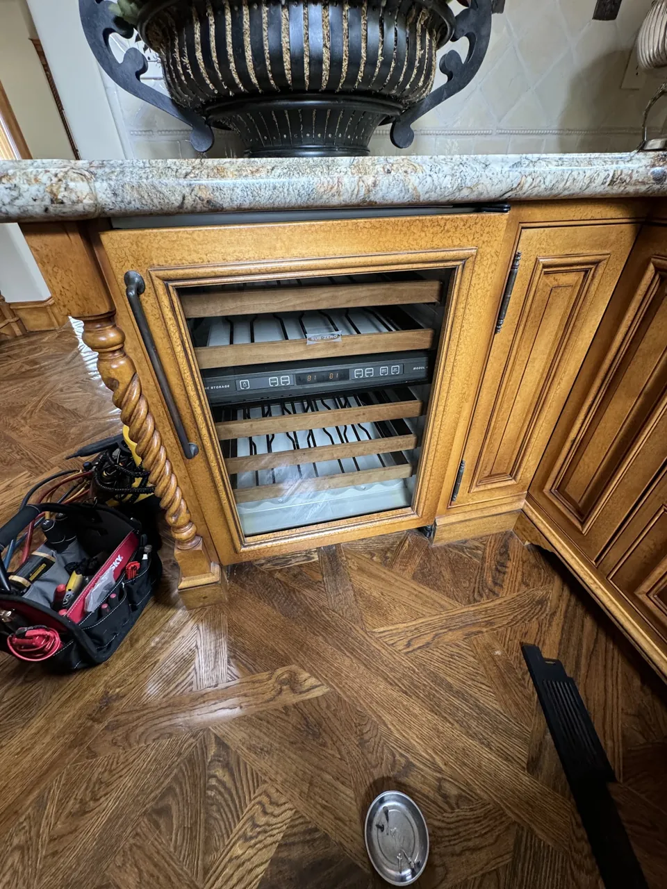 Built-in Sub-Zero wine cooler with the door open in a wood-panel kitchen