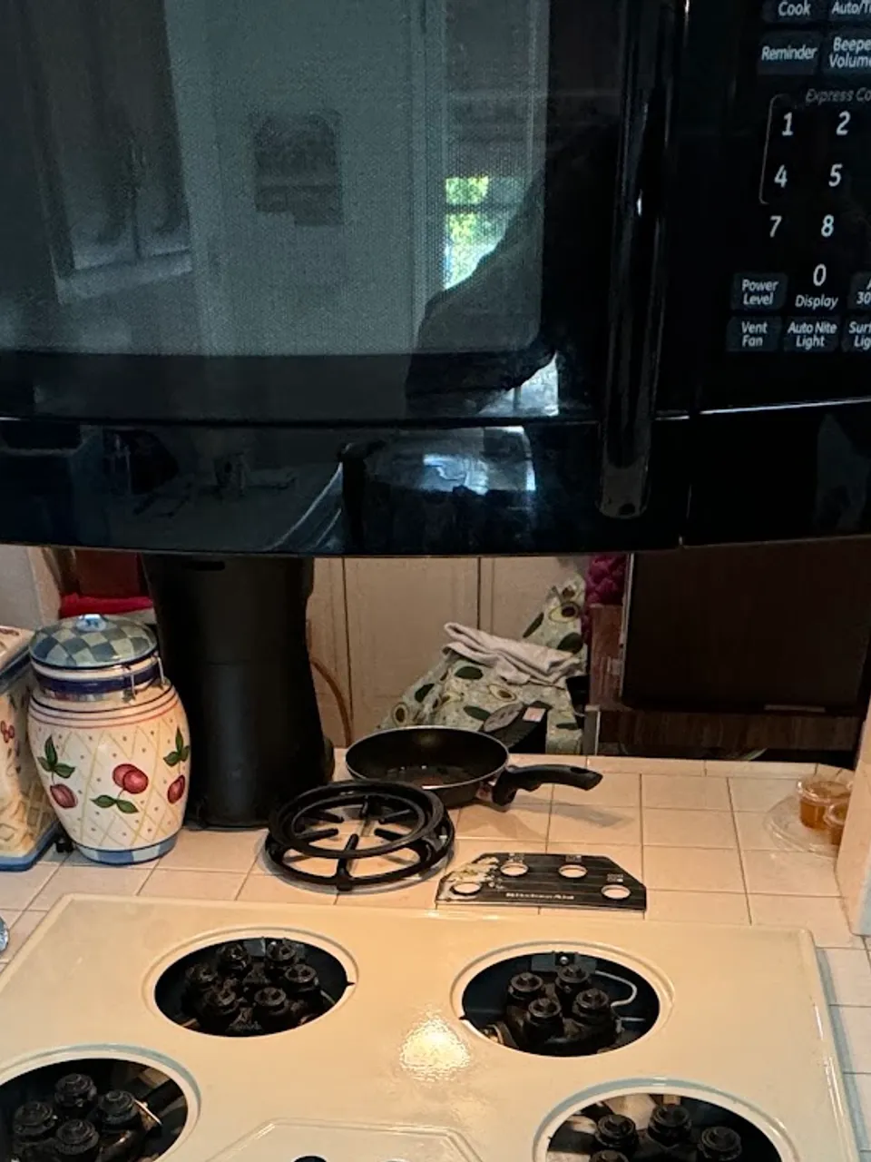 Disassembled electric cooktop below an over-the-range microwave