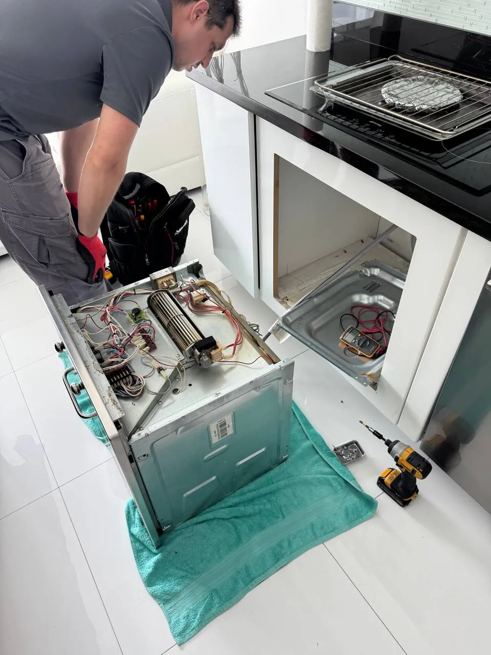 Built-in oven pulled out of the cabinet and opened up on the floor