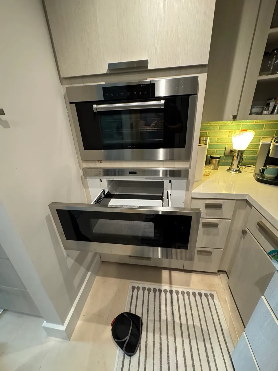 Stainless microwave drawer pulled open under a built-in wall oven