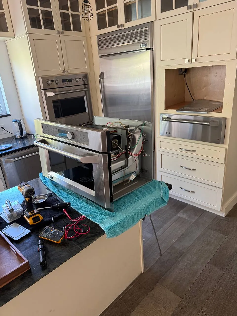 Built-in microwave pulled out of the cabinet onto a work stand