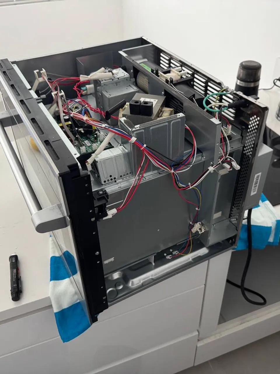 Microwave internals laid open on the countertop during the repair