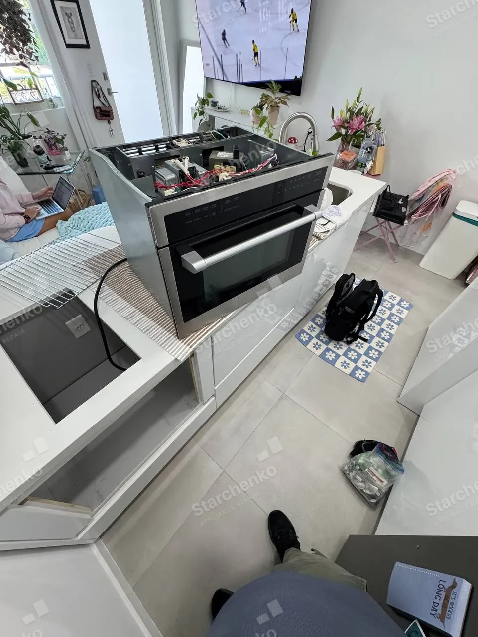 Bosch built-in microwave slid out of the cabinet with the top cover off and the transformer exposed