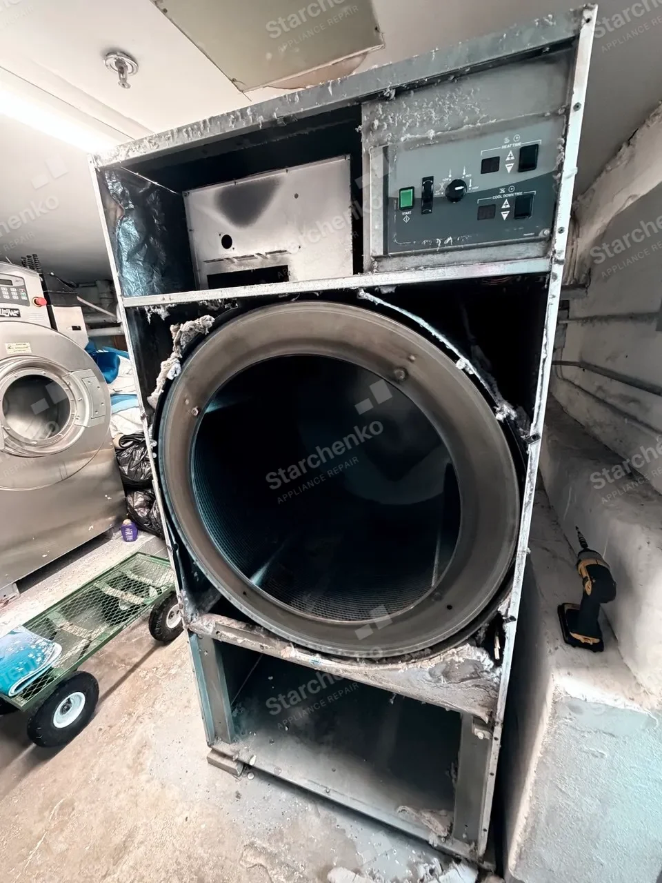 Wascomat commercial dryer opened with its drum, lint filter housing, blower and vent path exposed