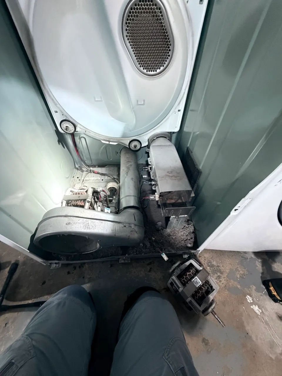 Dryer blower housing and drive motor exposed during the repair