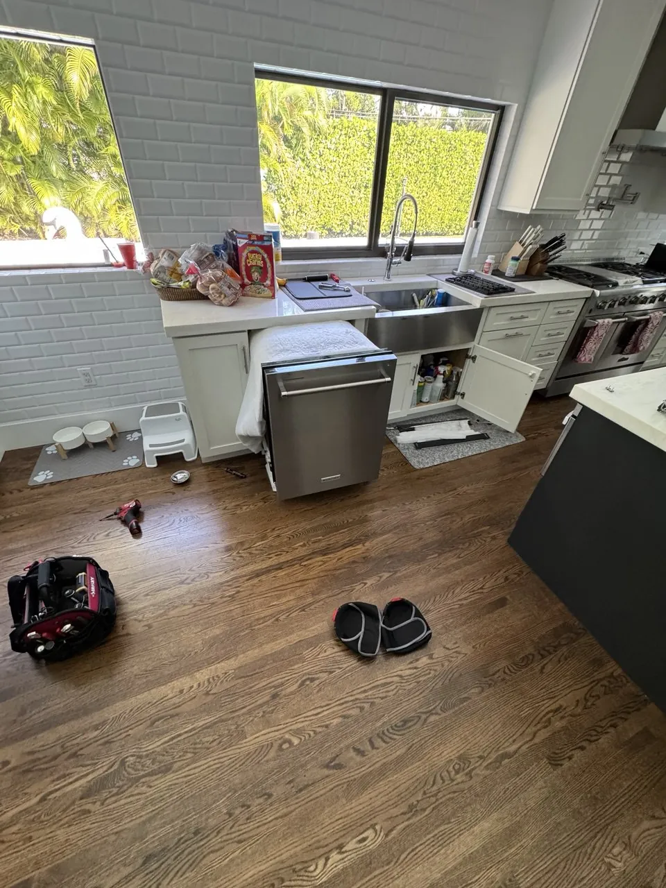 Dishwasher pulled out from under the counter in a bright kitchen
