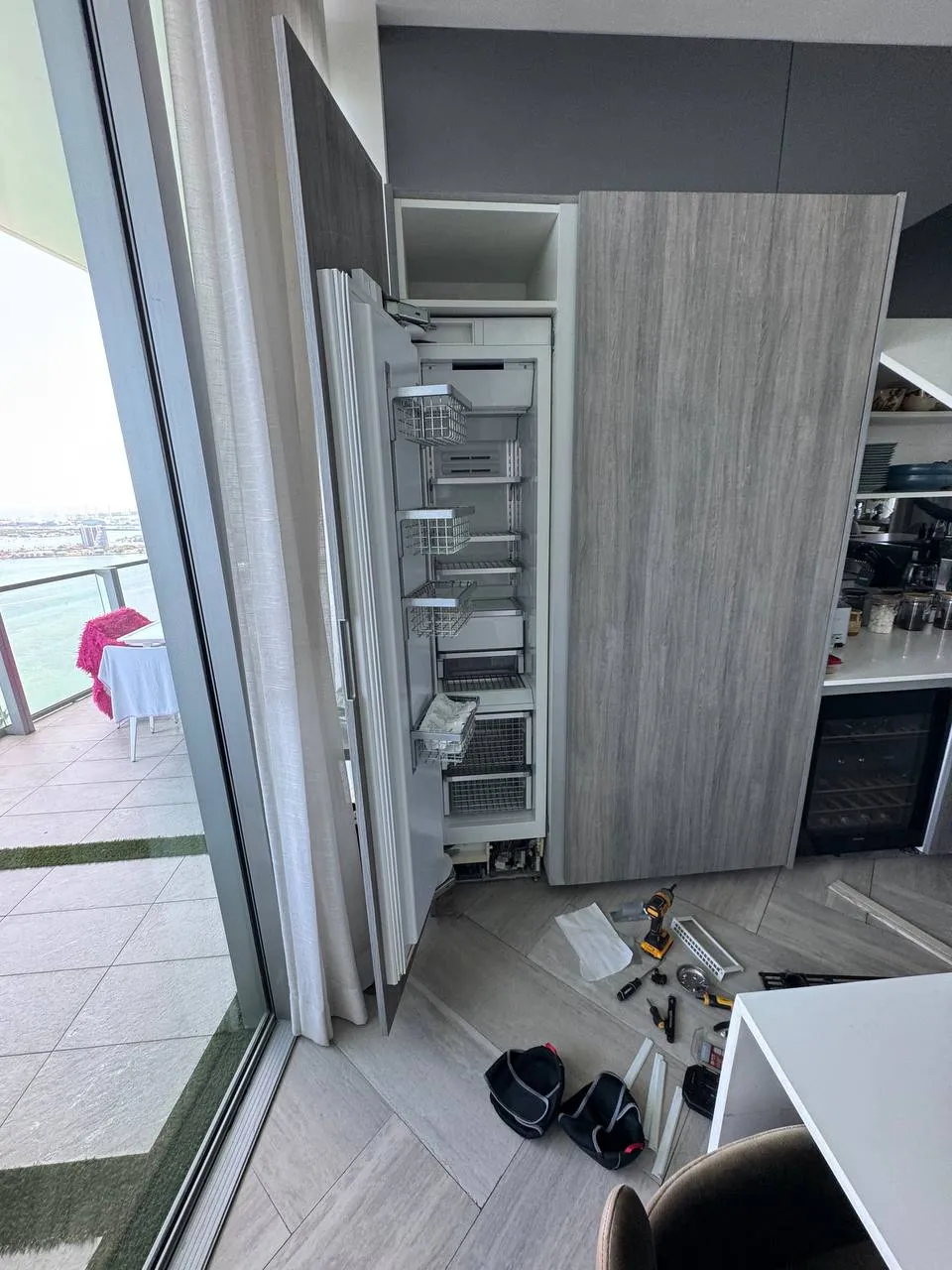 Panel-ready built-in refrigerator column with the door open during the repair