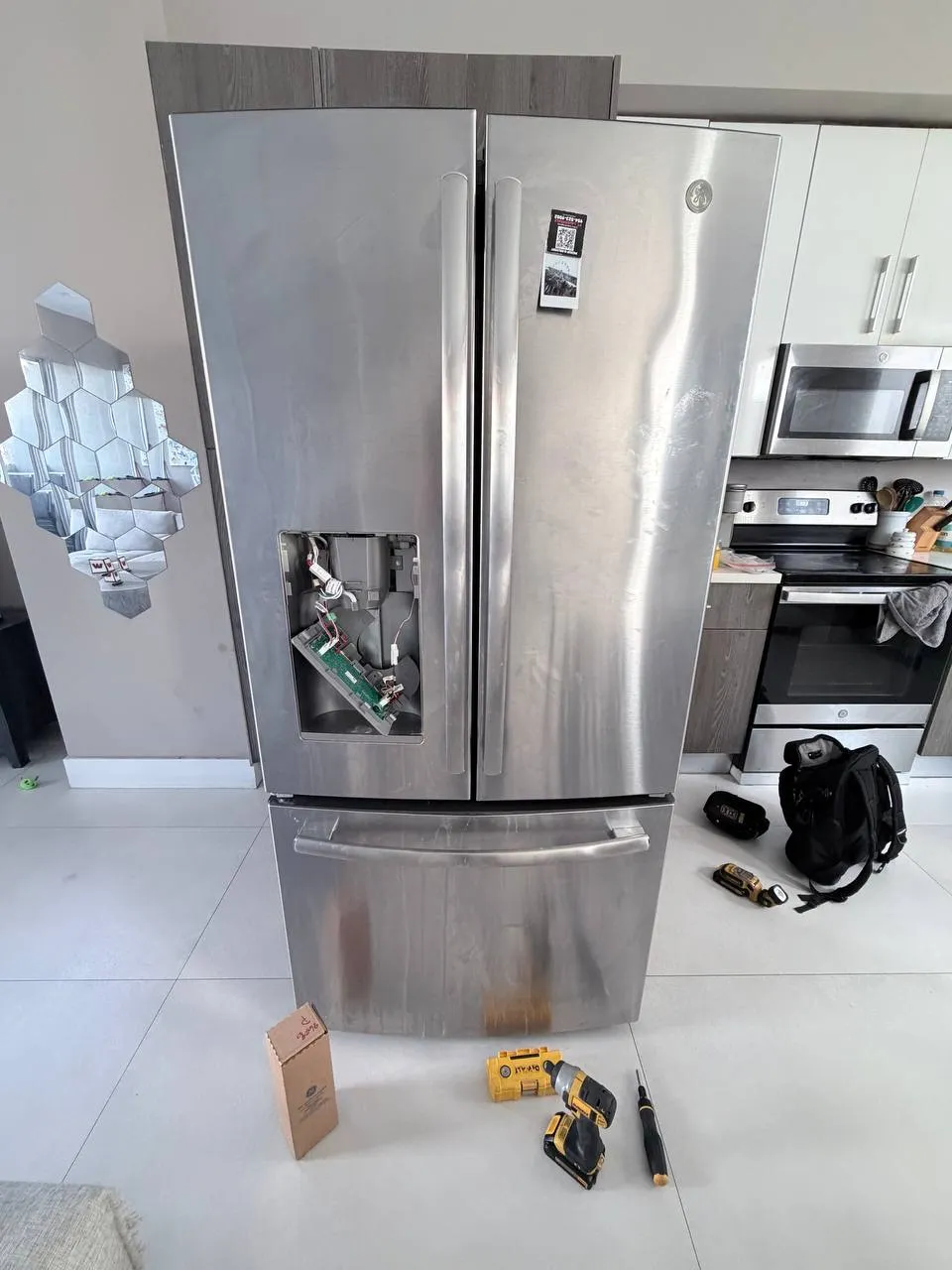 French-door refrigerator with the dispenser panel opened and its board exposed