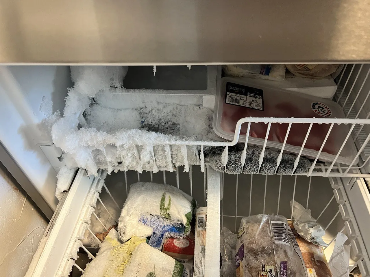 Freezer shelf and baskets covered in frost buildup