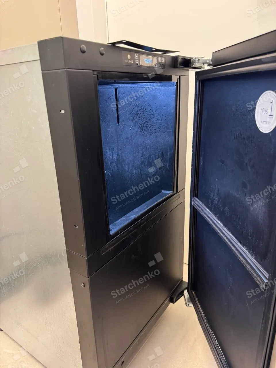 U-Line commercial ice machine with its door open and frost inside the empty bin