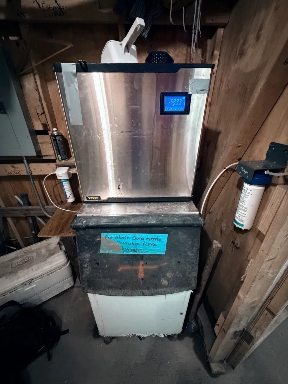 Floor-standing VEVOR commercial ice machine on a storage bin beside a water filter