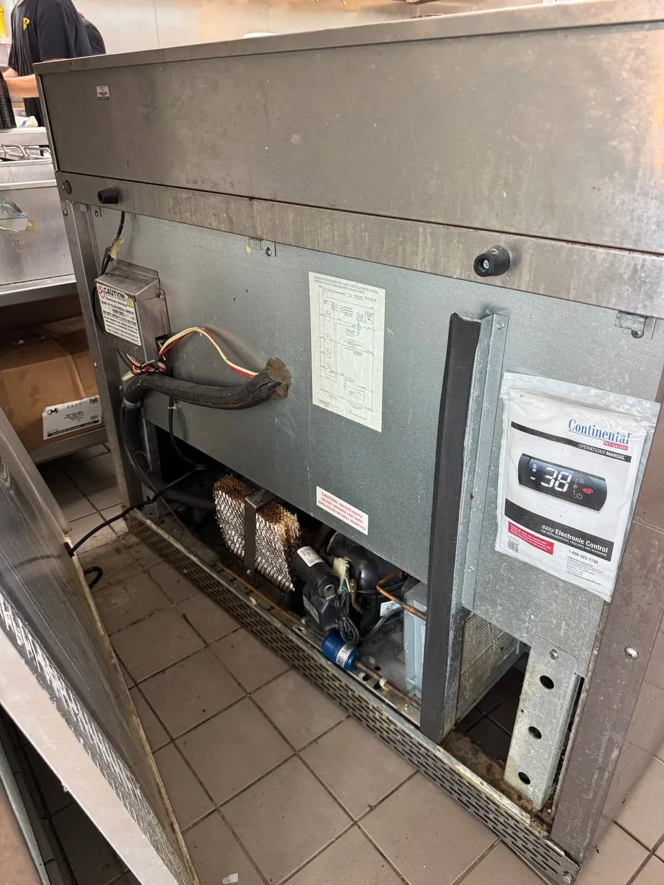 Continental commercial cooler with the front panel removed and refrigeration components exposed
