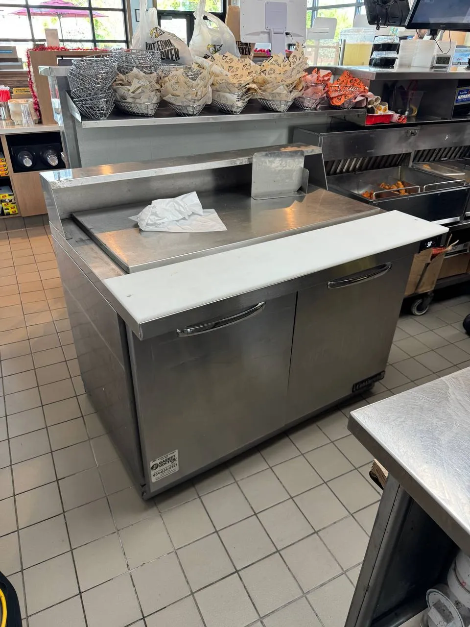 Stainless Continental refrigerated prep table in a restaurant service area