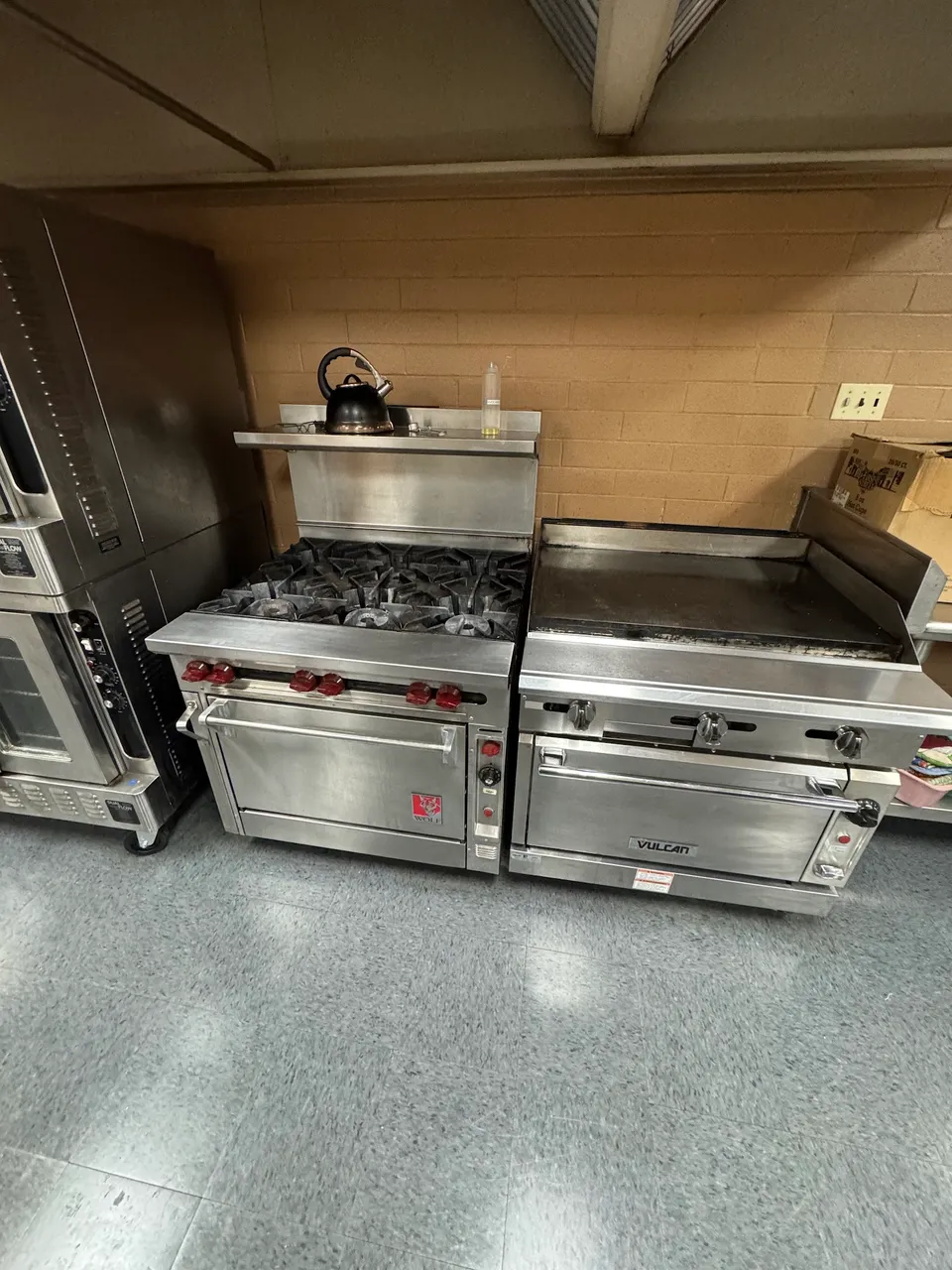 Commercial kitchen line with a Wolf range oven, Vulcan griddle oven and convection oven