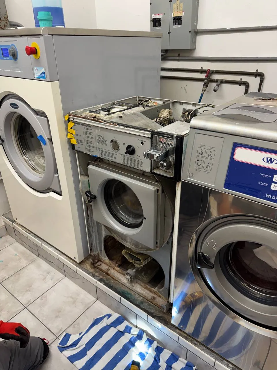 Commercial washer by Wascomat with the top, control panel and lower service panel open