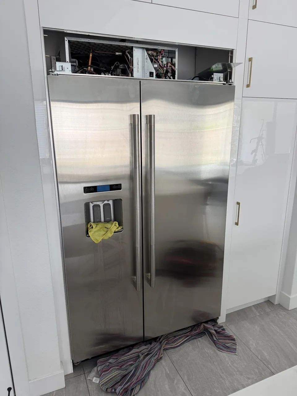 Built-in side-by-side refrigerator with the top compressor compartment open