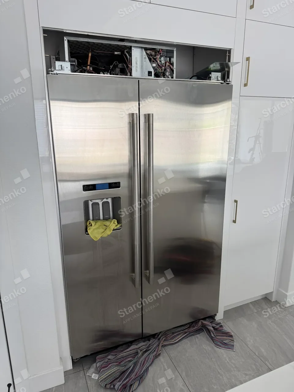 Thermador built-in side-by-side refrigerator with the top compressor compartment open