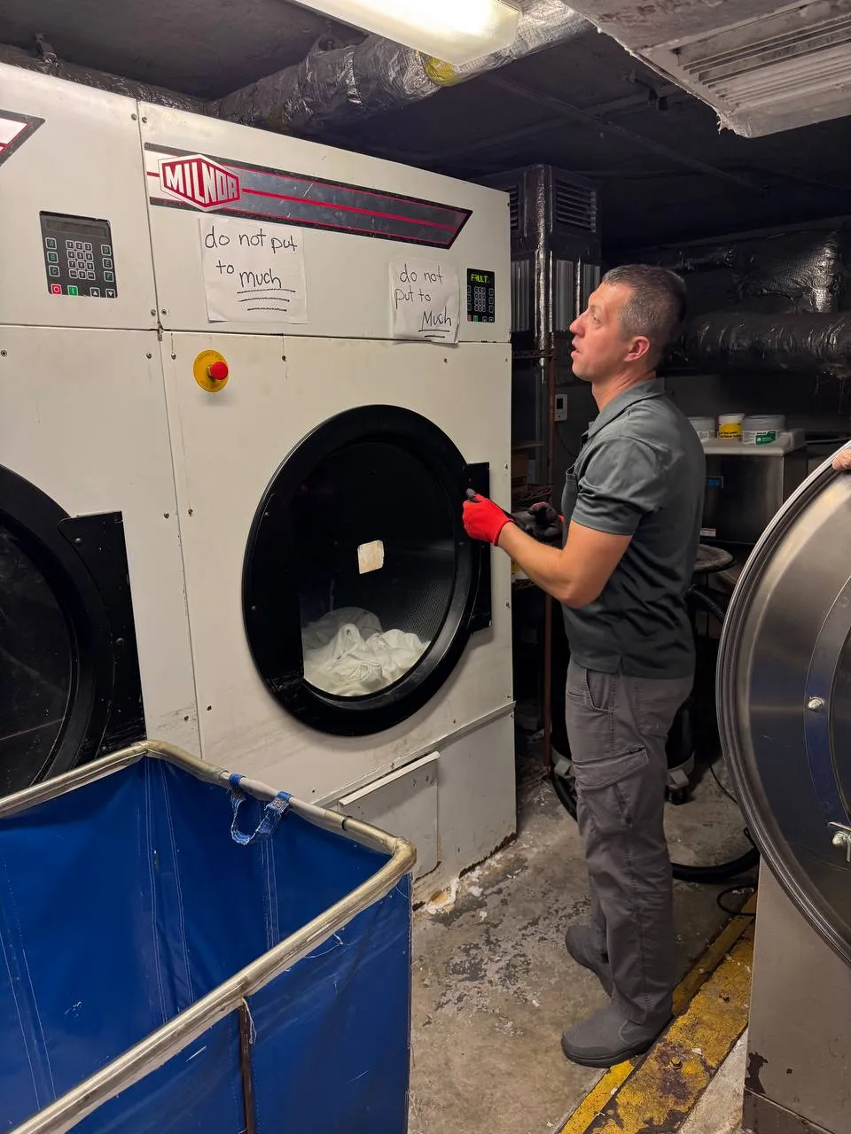 Commercial dryer by Milnor showing a fault code with its door open for a switch check