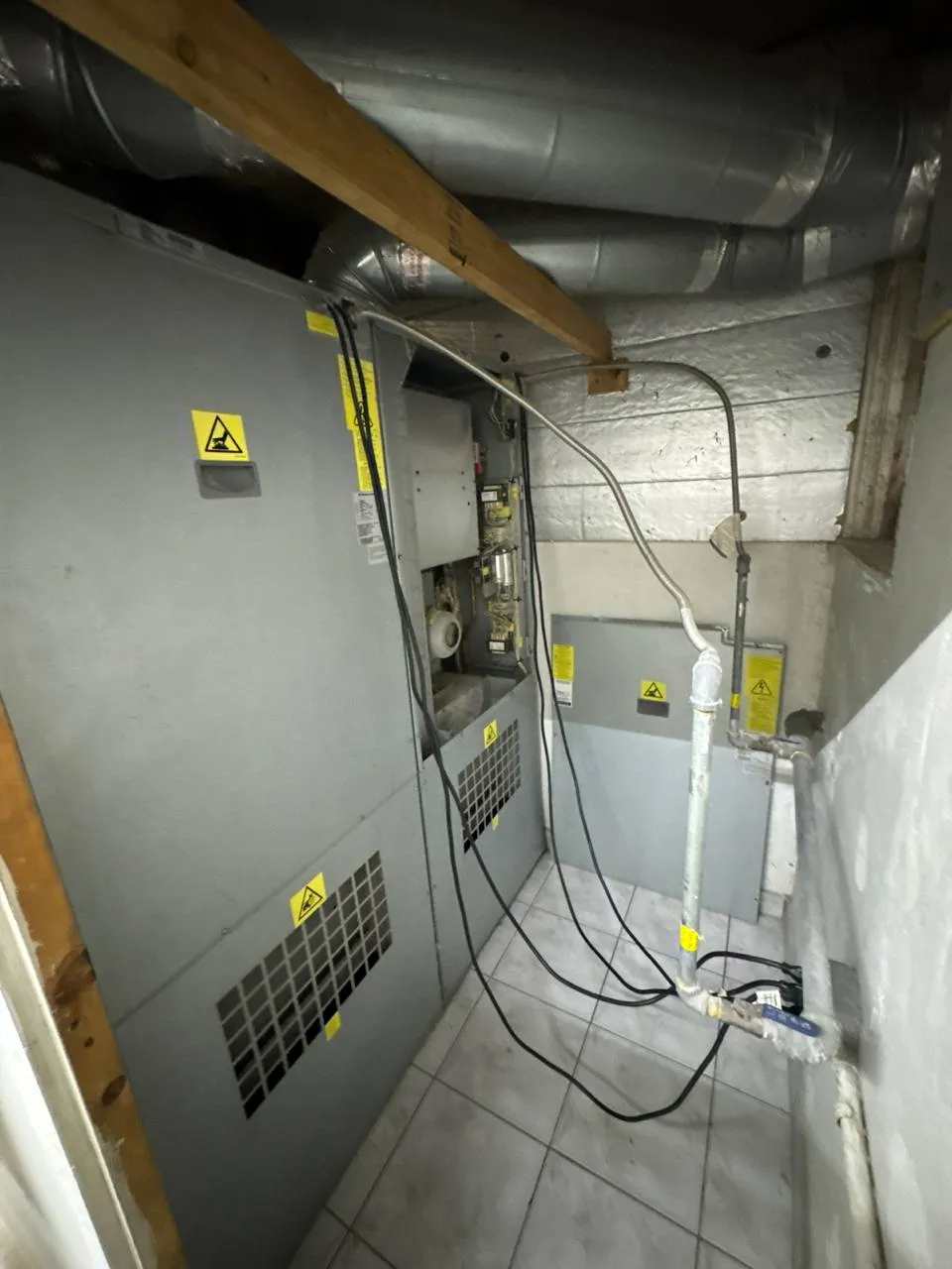 Commercial dryer powered by gas with its service panel removed and burner section exposed