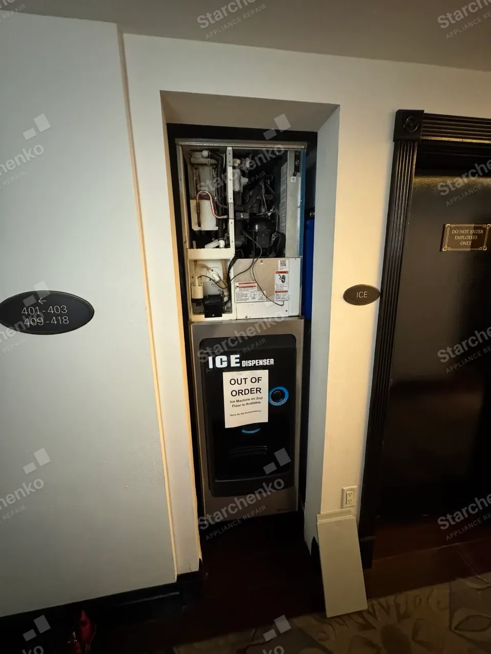 Hotel corridor Scotsman ice machine dispenser with its top panel removed, exposing the compressor and lines